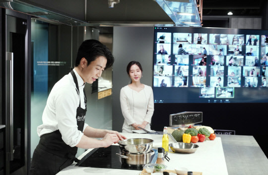 지난 18일 서울시 강남구 논현동에 위치한 시그니처 키친 스위트 논현 쇼룸에서 손종원 셰프(사진 왼쪽)와 이혜성 아나운서가 화상채팅서비스 줌을 활용해 요리 강의를 진행하고 있다. <LG전자 제공>